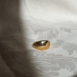 Gold ring on a textured white fabric background